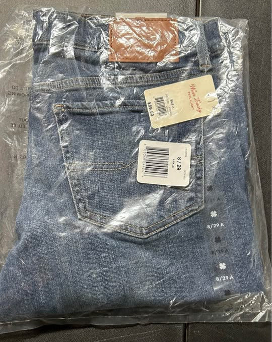 Blue jeans with tags on a black surface